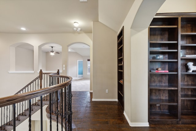 corridor featuring arched walkways, recessed lighting, vaulted ceiling, an upstairs landing, and baseboards