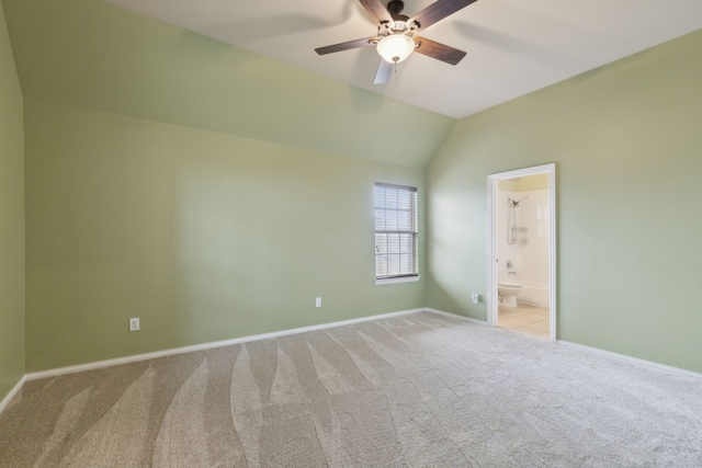 spare room with carpet floors, vaulted ceiling, baseboards, and a ceiling fan