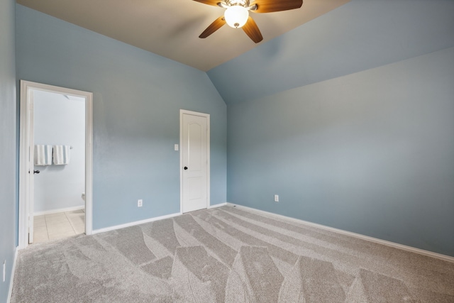 unfurnished bedroom with baseboards, connected bathroom, lofted ceiling, ceiling fan, and carpet floors