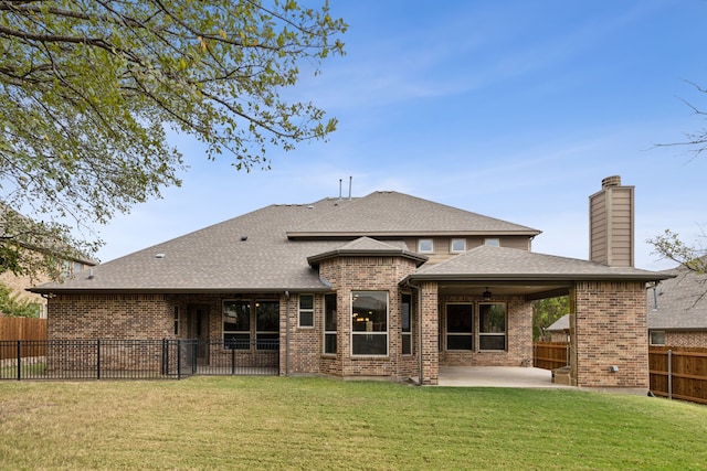 rear view of property with a fenced backyard, a patio, brick siding, and a lawn