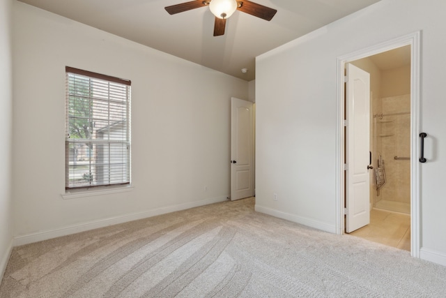 unfurnished bedroom with baseboards, ensuite bathroom, and light colored carpet