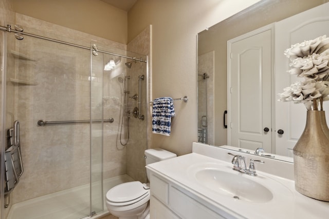 bathroom featuring a shower stall, toilet, and vanity