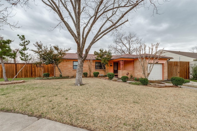 ranch-style house featuring brick siding, an attached garage, fence, and a front yard