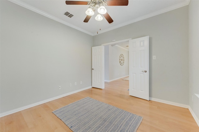 unfurnished bedroom with light wood finished floors, baseboards, visible vents, and ornamental molding