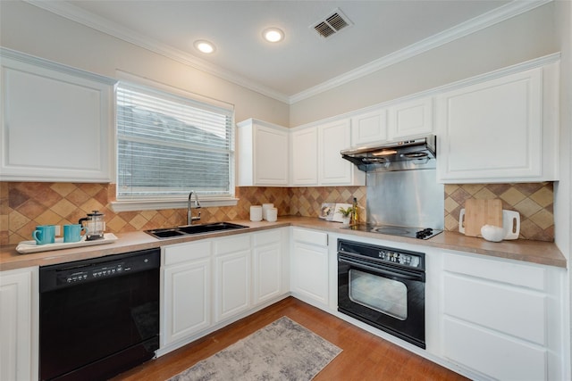 kitchen featuring visible vents, wood finished floors, under cabinet range hood, black appliances, and a sink