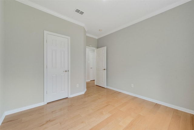 unfurnished bedroom with light wood-style floors, visible vents, crown molding, and baseboards