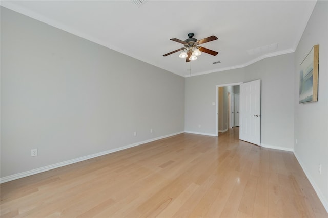 spare room featuring crown molding, visible vents, light wood-style floors, ceiling fan, and baseboards