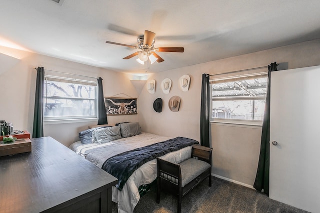 bedroom with ceiling fan, dark carpet, and baseboards