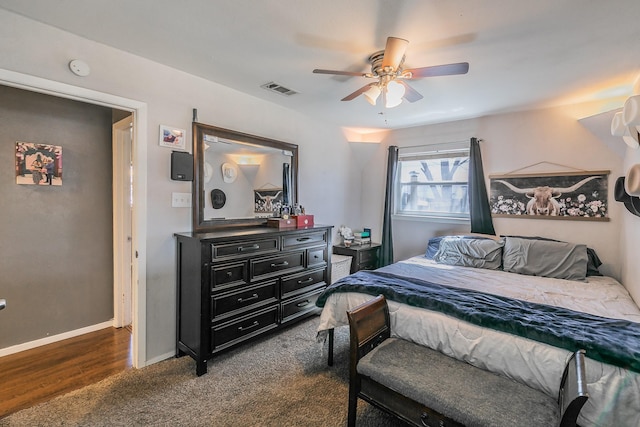 bedroom with ceiling fan, dark colored carpet, visible vents, and baseboards