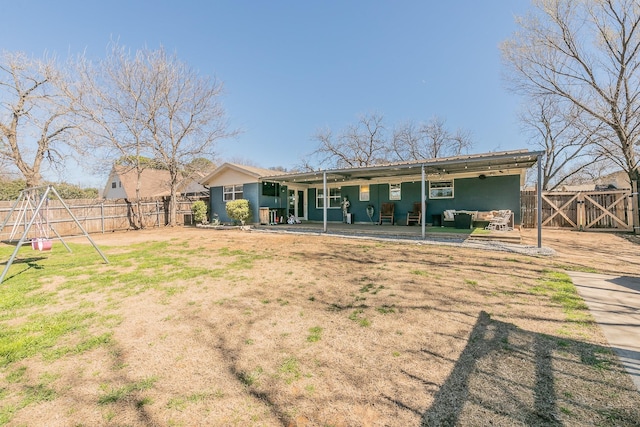 rear view of property with outdoor lounge area, a patio area, fence, and a gate