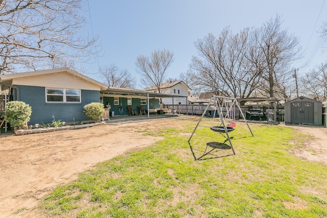 back of house with an outbuilding, a lawn, fence, and a storage unit