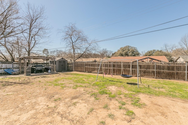 view of yard featuring a storage shed, an outdoor structure, and a fenced backyard