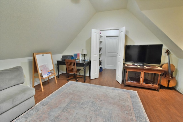 home office featuring lofted ceiling, baseboards, and wood finished floors