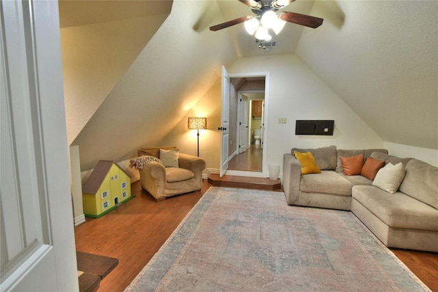 living area featuring vaulted ceiling, ceiling fan, wood finished floors, and visible vents