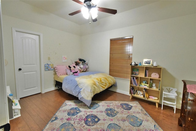 bedroom with a ceiling fan, baseboards, and wood finished floors