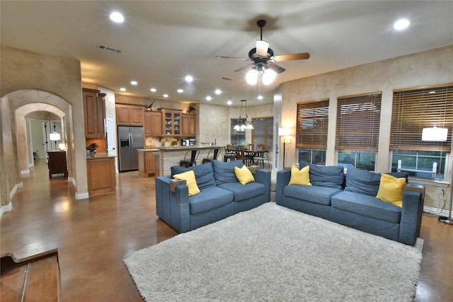 living room with arched walkways, recessed lighting, visible vents, a ceiling fan, and concrete floors