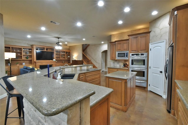 kitchen with a warming drawer, stainless steel appliances, recessed lighting, a spacious island, and a sink