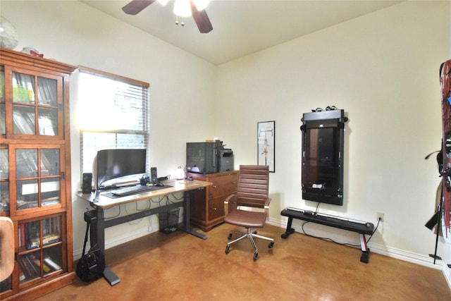 carpeted office space featuring a ceiling fan and baseboards