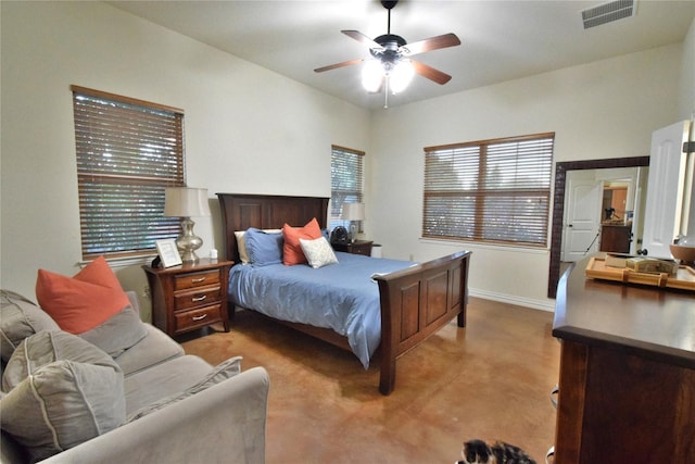 bedroom with concrete flooring, visible vents, baseboards, and a ceiling fan