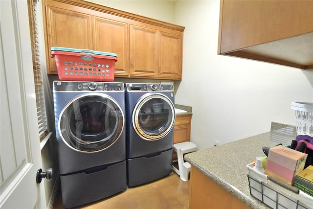 washroom with washer and clothes dryer and cabinet space