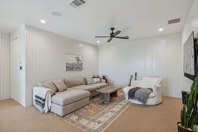 living area featuring carpet floors, visible vents, and wallpapered walls