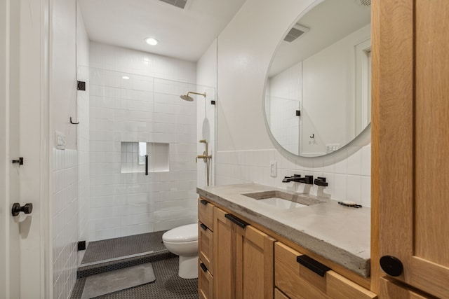 full bath with toilet, vanity, tile walls, tiled shower, and tile patterned floors