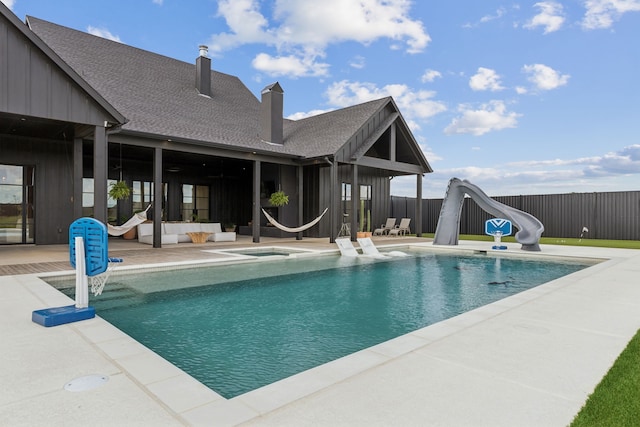 view of pool featuring a fenced in pool, a patio, fence, an in ground hot tub, and a water slide