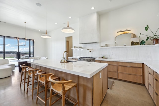 kitchen featuring finished concrete floors, a breakfast bar, a sink, and decorative backsplash