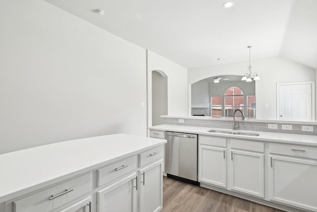 kitchen featuring lofted ceiling, a sink, light countertops, stainless steel dishwasher, and light wood-type flooring