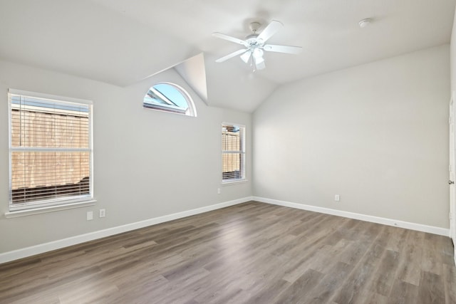 unfurnished room featuring ceiling fan, vaulted ceiling, baseboards, and wood finished floors