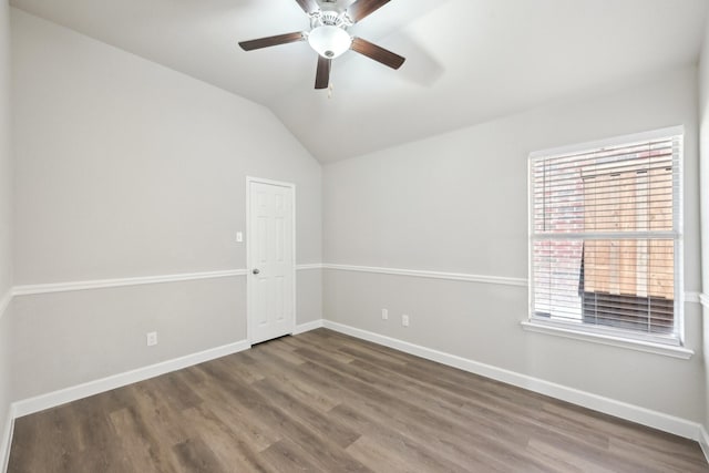 spare room with lofted ceiling, ceiling fan, baseboards, and wood finished floors