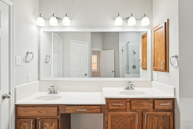 bathroom with a stall shower, a sink, and double vanity