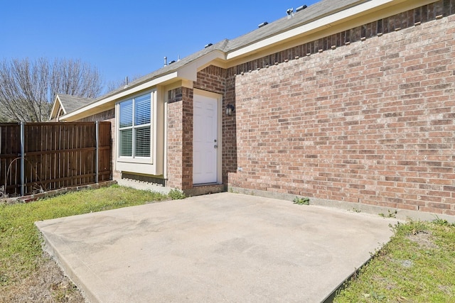 exterior space featuring brick siding, a patio area, and fence