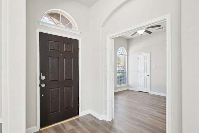 entryway featuring visible vents, ceiling fan, baseboards, and wood finished floors