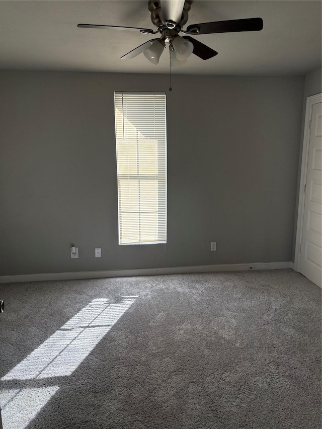 empty room with a ceiling fan, carpet, and baseboards