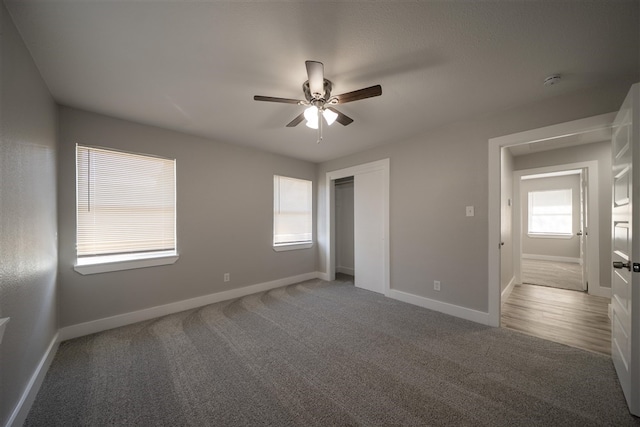 unfurnished bedroom featuring carpet floors, a closet, ceiling fan, and baseboards