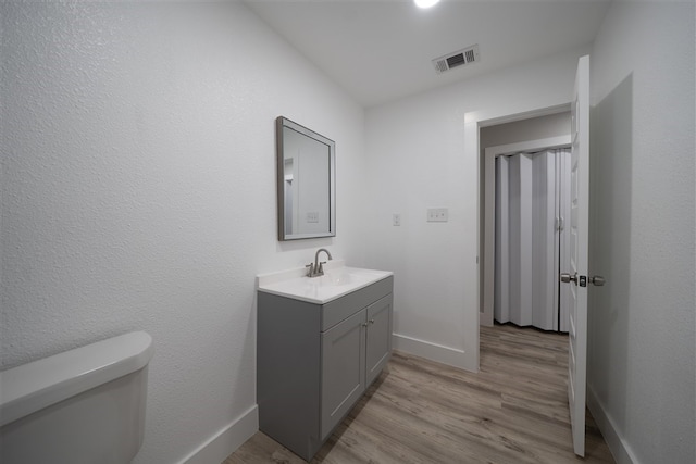 bathroom featuring baseboards, visible vents, and wood finished floors