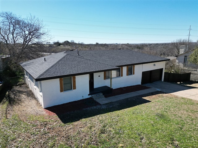 view of front of property with brick siding, a shingled roof, concrete driveway, an attached garage, and a front lawn