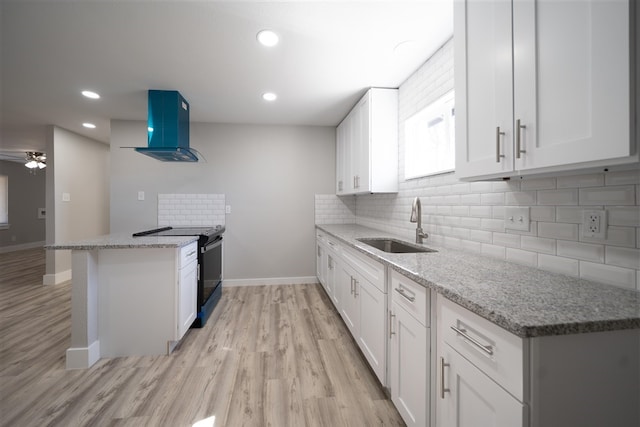 kitchen featuring black / electric stove, a peninsula, a sink, white cabinetry, and range hood