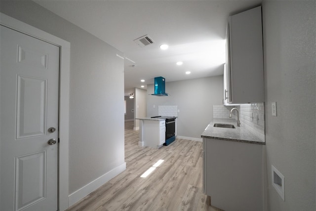 kitchen featuring range hood, tasteful backsplash, visible vents, electric range oven, and a sink