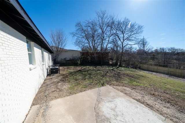 view of yard with central AC unit, a patio area, and a fenced backyard