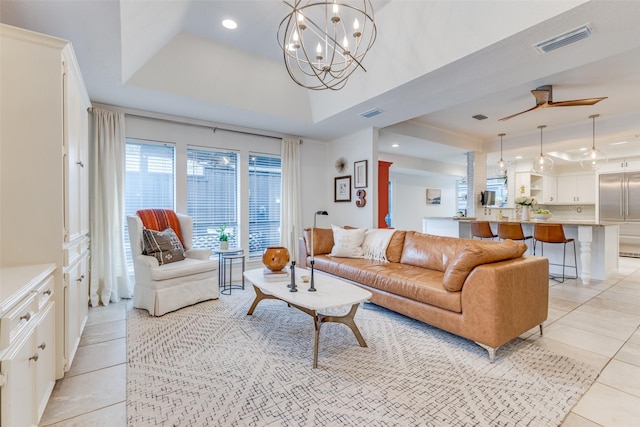 living room featuring light tile patterned floors, recessed lighting, ceiling fan with notable chandelier, visible vents, and a raised ceiling