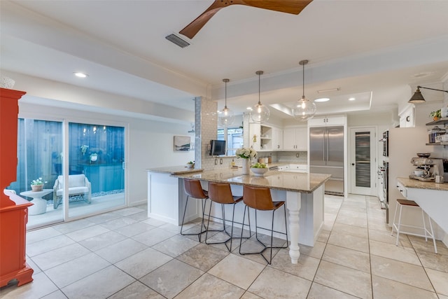 kitchen featuring a peninsula, built in refrigerator, white cabinetry, open shelves, and a raised ceiling