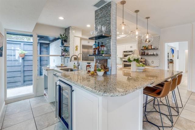 kitchen featuring wine cooler, a sink, visible vents, decorative backsplash, and open shelves