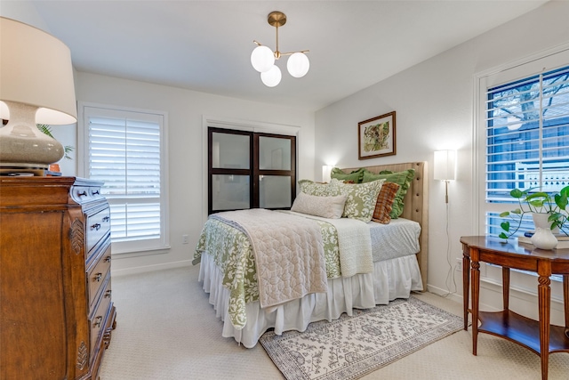 bedroom featuring light colored carpet, baseboards, and an inviting chandelier