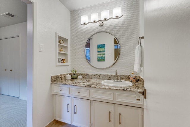 bathroom with wallpapered walls, visible vents, and vanity