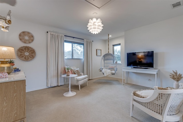 living area with carpet floors, attic access, visible vents, and baseboards