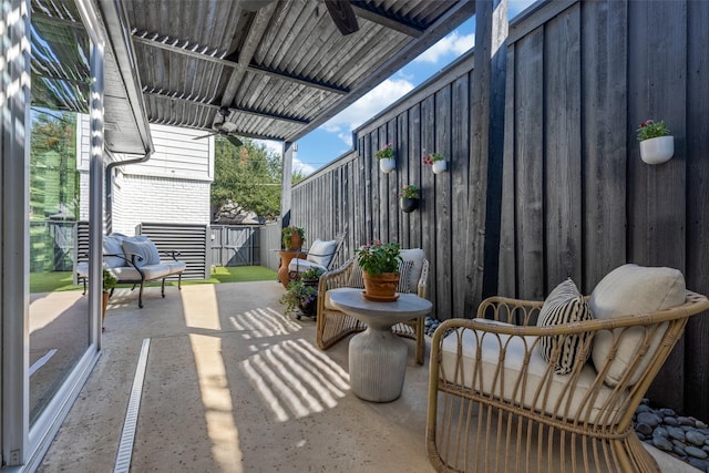 view of patio / terrace with ceiling fan and fence