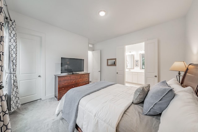 bedroom with light carpet, baseboards, and ensuite bathroom