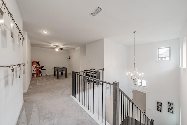 hallway featuring light carpet, visible vents, an upstairs landing, a chandelier, and recessed lighting